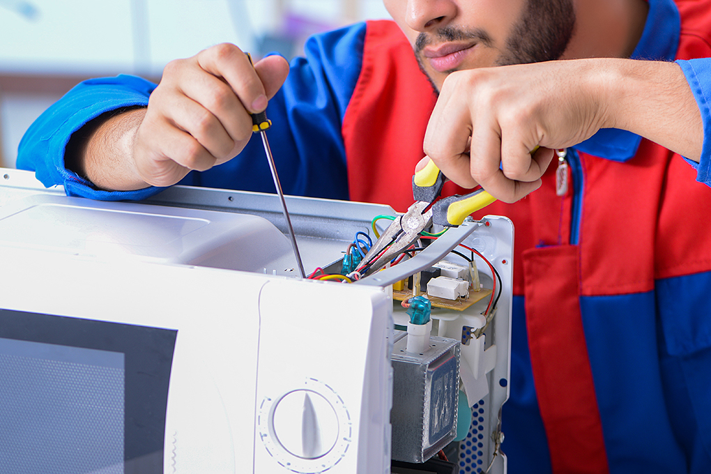Technician testing wiring on a dishwasher